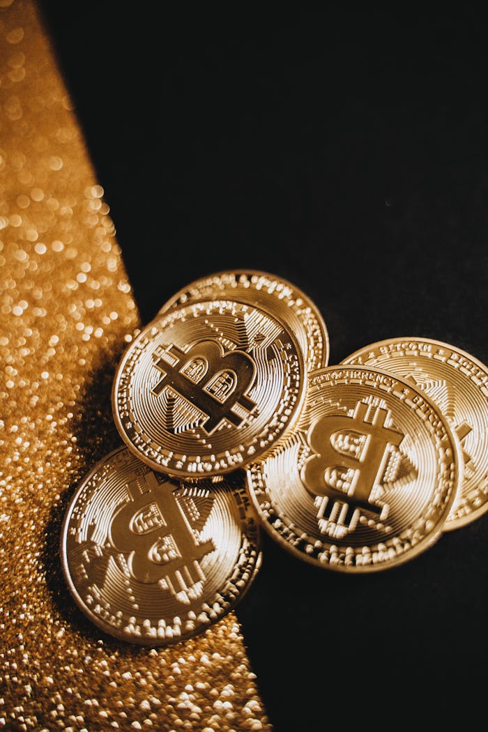 Stack of golden Bitcoin coins on a sparkling gold and black backdrop, symbolizing cryptocurrency wealth.